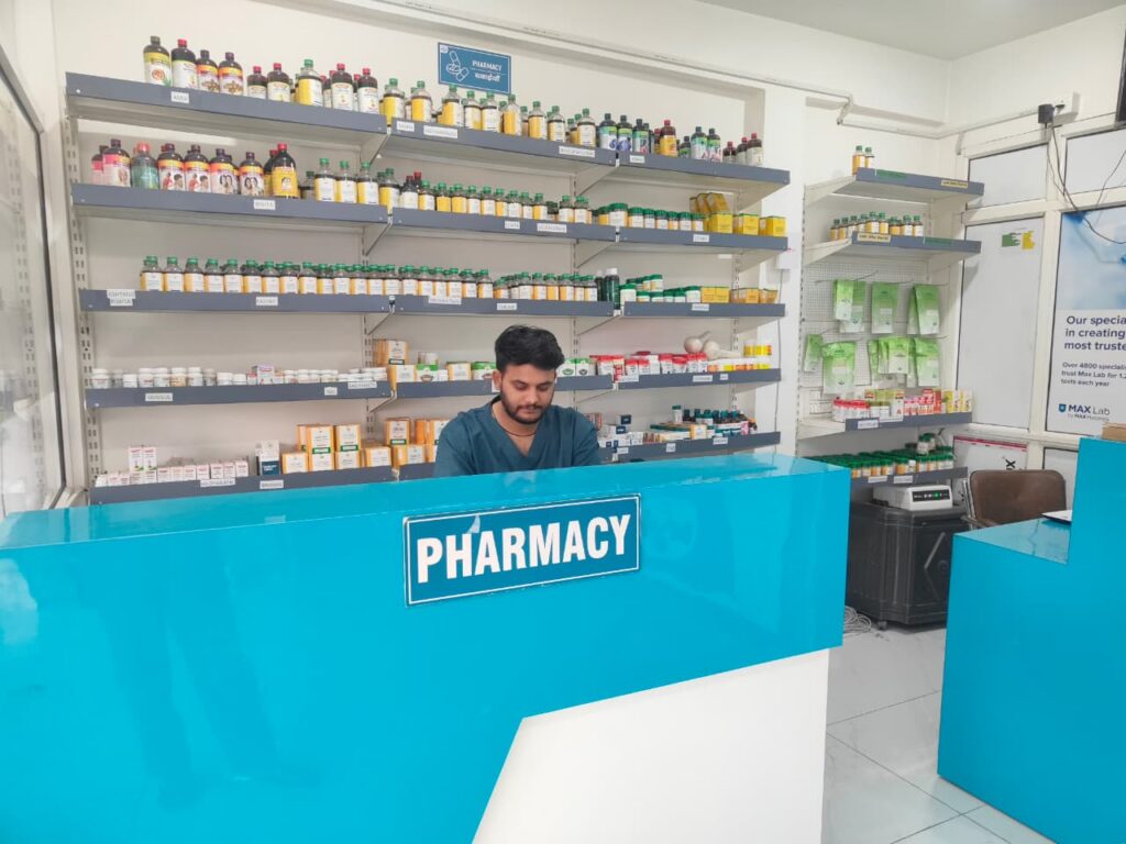 In-house Ayurvedic pharmacy counter at MSM Ayurveda clinic in Dehradun with a pharmacist at the desk.
